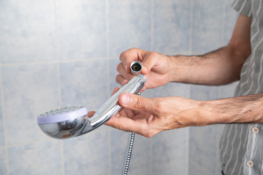 Someone screwing in a new shower head.