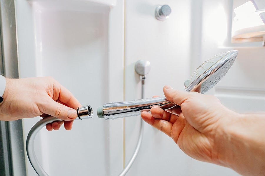Someone unscrewing the old shower head.