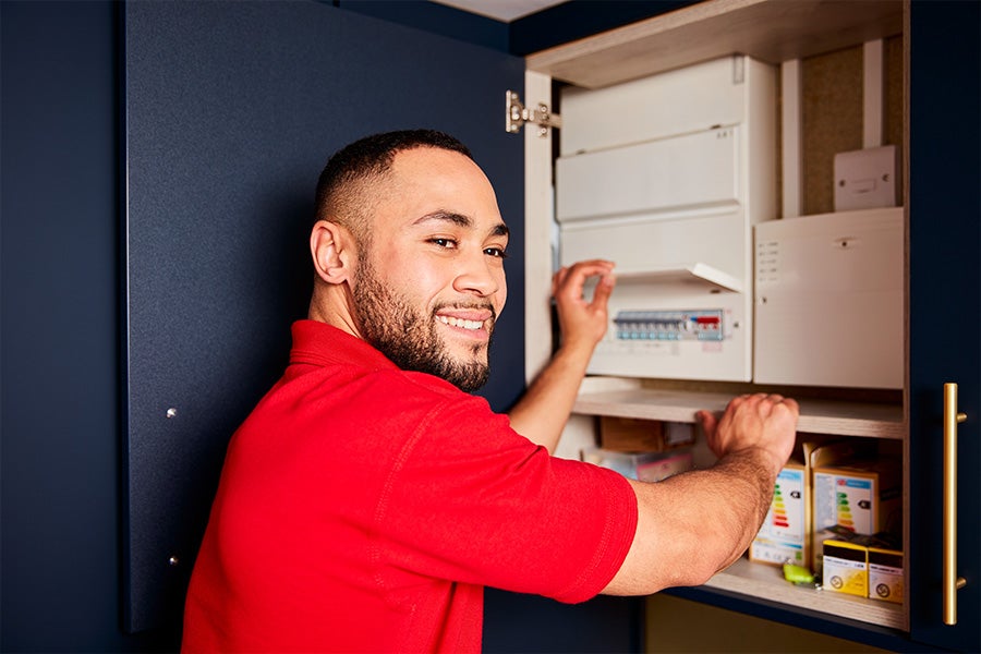A HomeServe electrician working on a customer’s electrics.