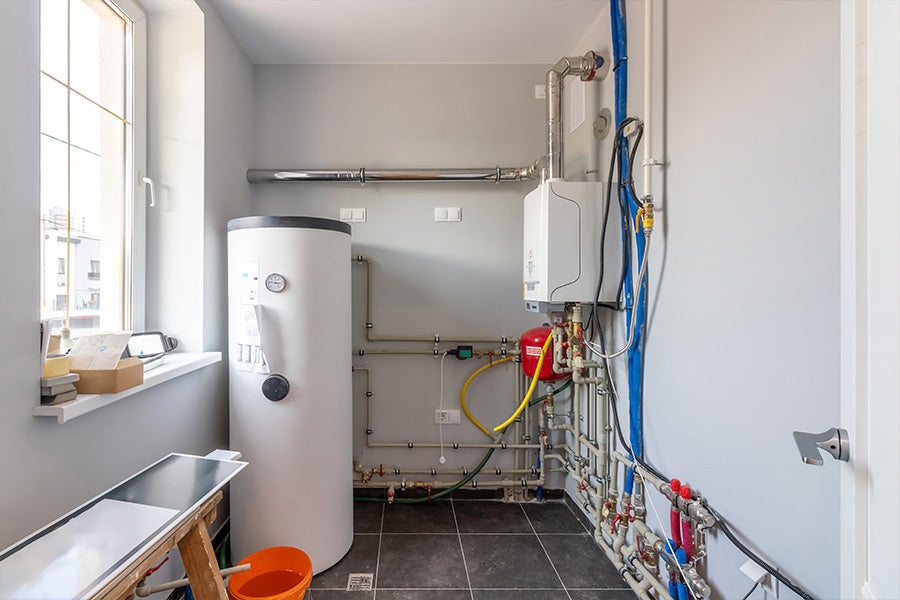 A hot water cylinder next to a boiler.