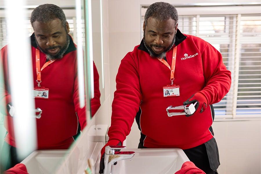 A HomeServe engineer replacing a tap.