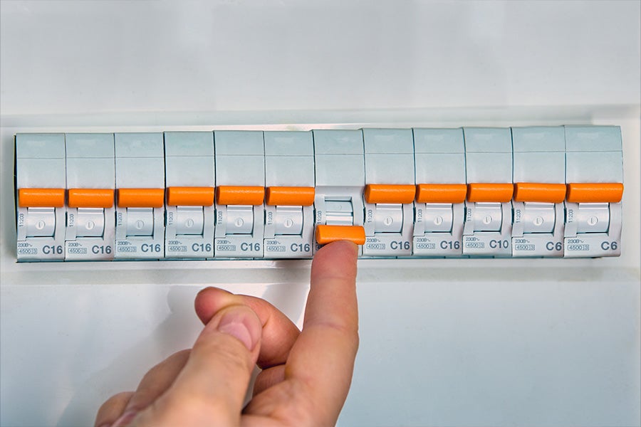 A tripped fuse in a fuse box. The homeowner is attempting to reset the fuse.