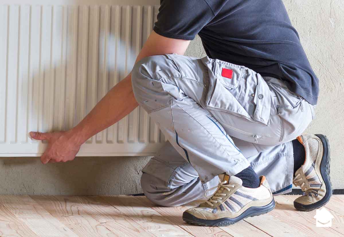 Man removing radiator from wall