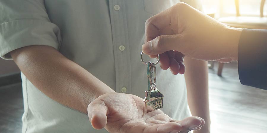 A landlord passing over keys to a tennant.