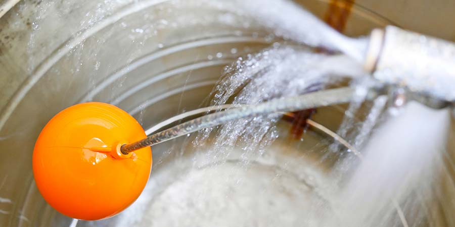 Inside a water tank. There is a flow of water coming in through a pipe, and a bright orange ball floats above the water.