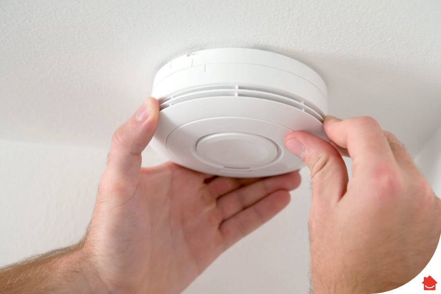 person fixing a smoke alarm - smoke and carbon monoxide alarm