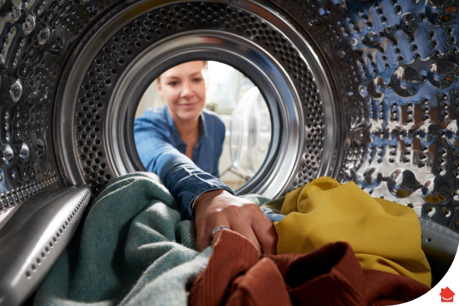 woman loading her tumble dryer - heat pump tumble dryer