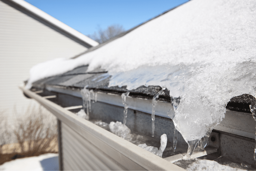 Dirty gutters damaged by water that has been blocked by debris and frozen in the winter