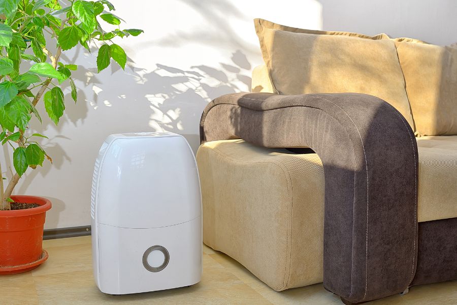 A dehumidifier in a living room to help stop condensation on windows