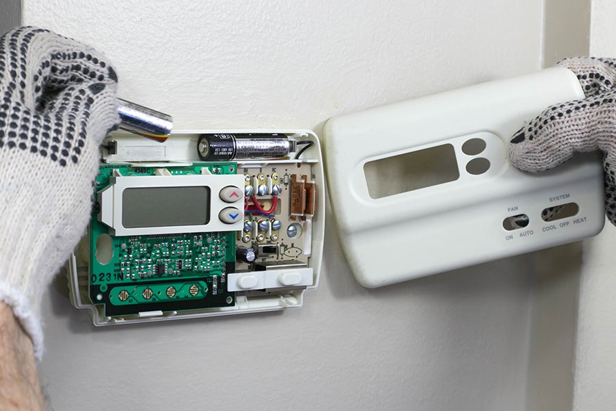 Batteries being replaced in a wireless thermostat.