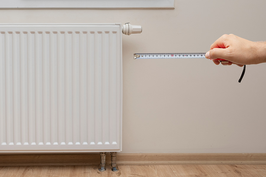 A radiator being measured for a room.