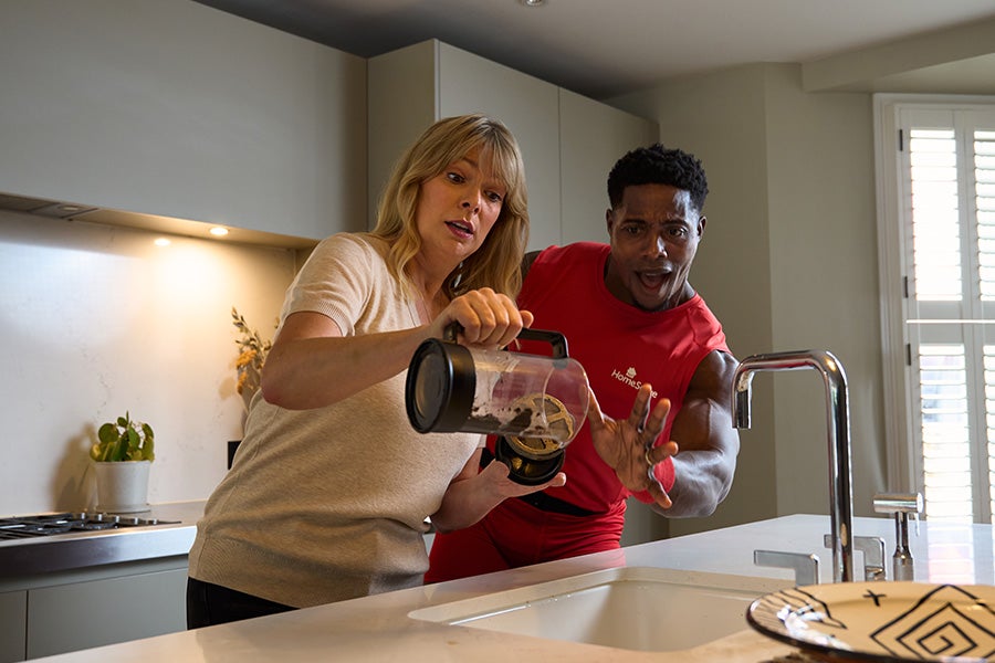 Harry Aikines-Aryeetey showing someone how to properly dispose of coffee grinds in the bin.