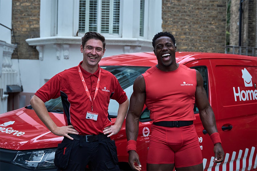 Harry Aikines-Aryeetey standing with a HomeServe engineer in front of a van.