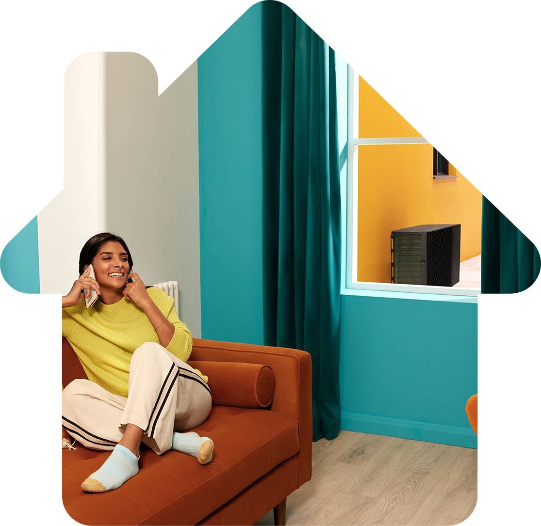 Happy smiling woman on the telephone relaxing in a warm colourful room