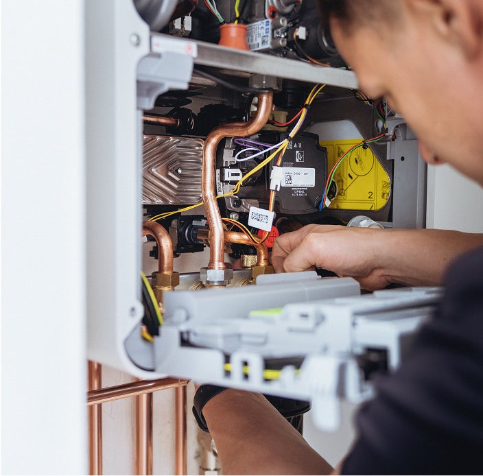 A BOXT engineer installing a new boiler with the internal components visible. 