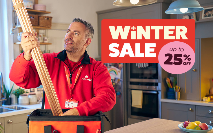 A HomeServe engineer next to a boiler with a badge that says 'Winter sale'