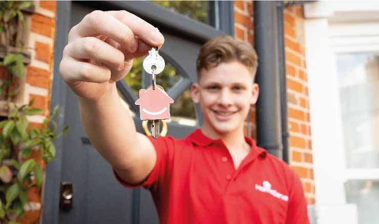 Freddie Brazier holding a key to university accommodation with a HomeServe key ring.