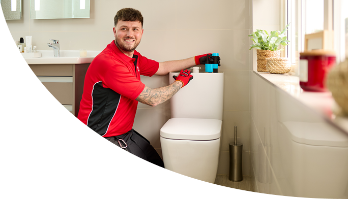 A HomeServe plumber repairing the flush mechanism of a toilet