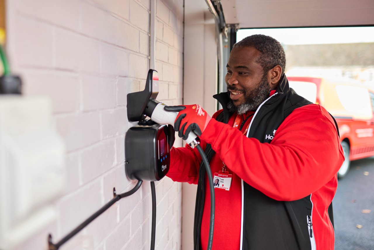A HomeServe electrician testing a home EV charger after a repair A HomeServe electrician testing a home EV charger after a repair