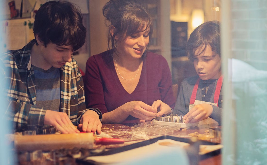 Mother and sons making cookies in kitchen