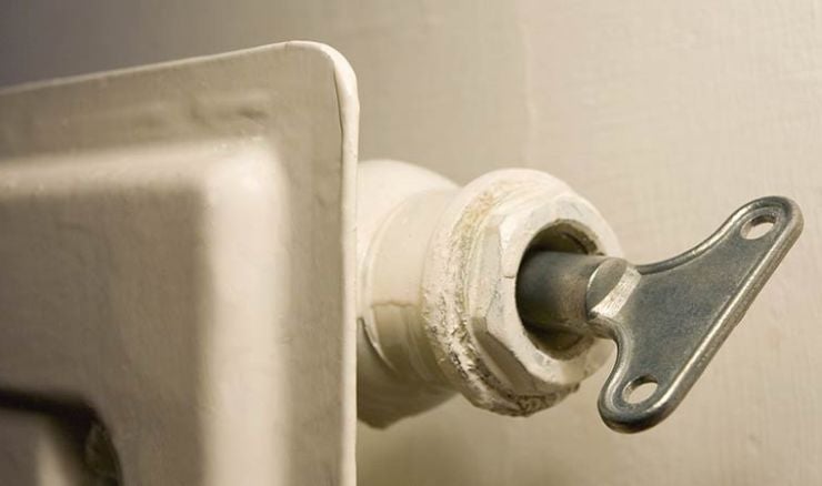 Radiator being bled with a radiator key.