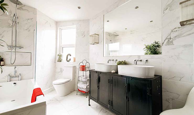 A white tiled bathroom with an unblocked bath