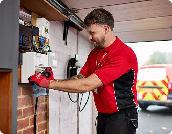 A HomeServe engineer repairing a fuse box for a customer with electrical cover.