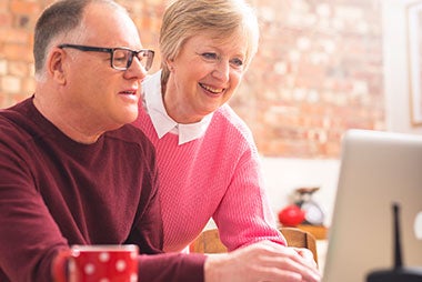 Couple looking at laptop - 'Email us'