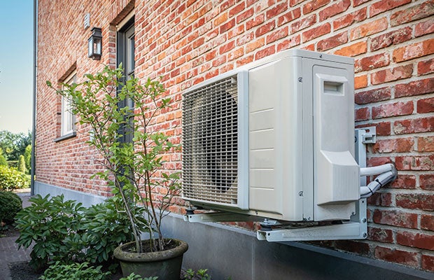 Heat pump on wall outside of property