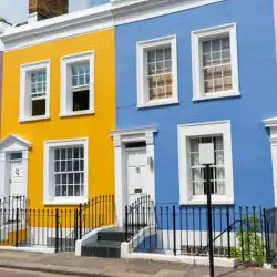 A row of multicoloured terraced houses owned by landlords