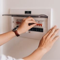 A tripped fuse box with a circuit breaker being reset