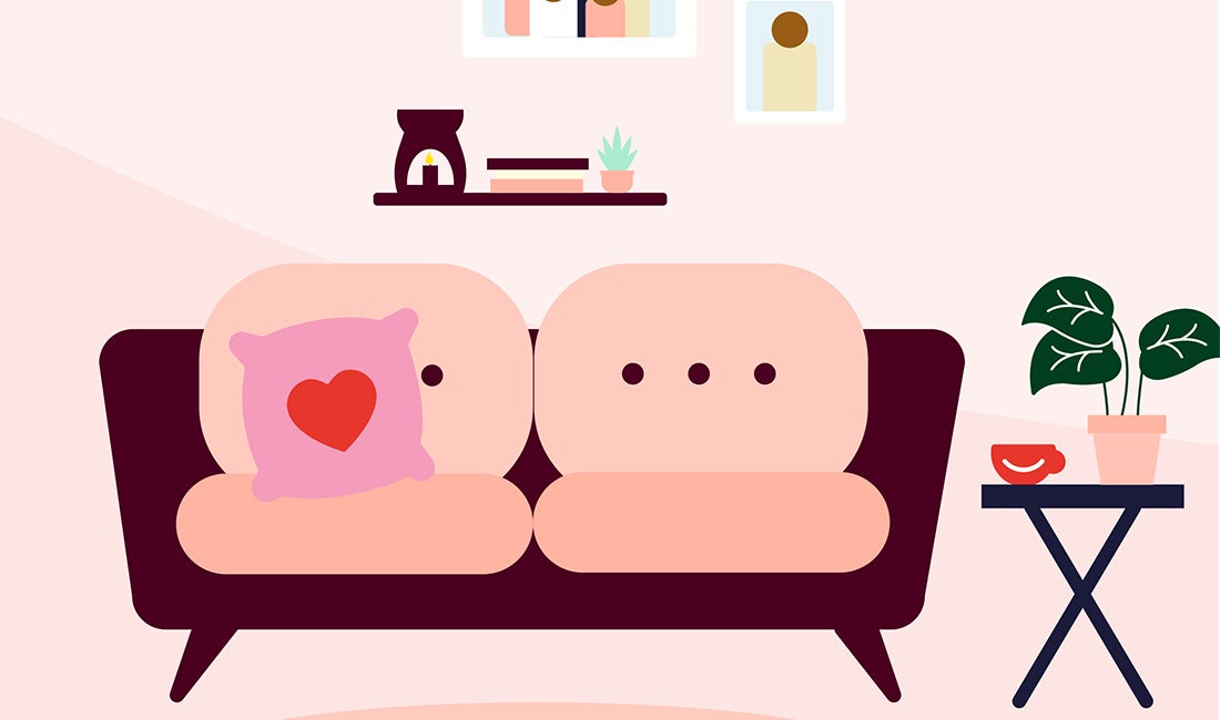 A cosy living room scene with a sofa and heart cushion